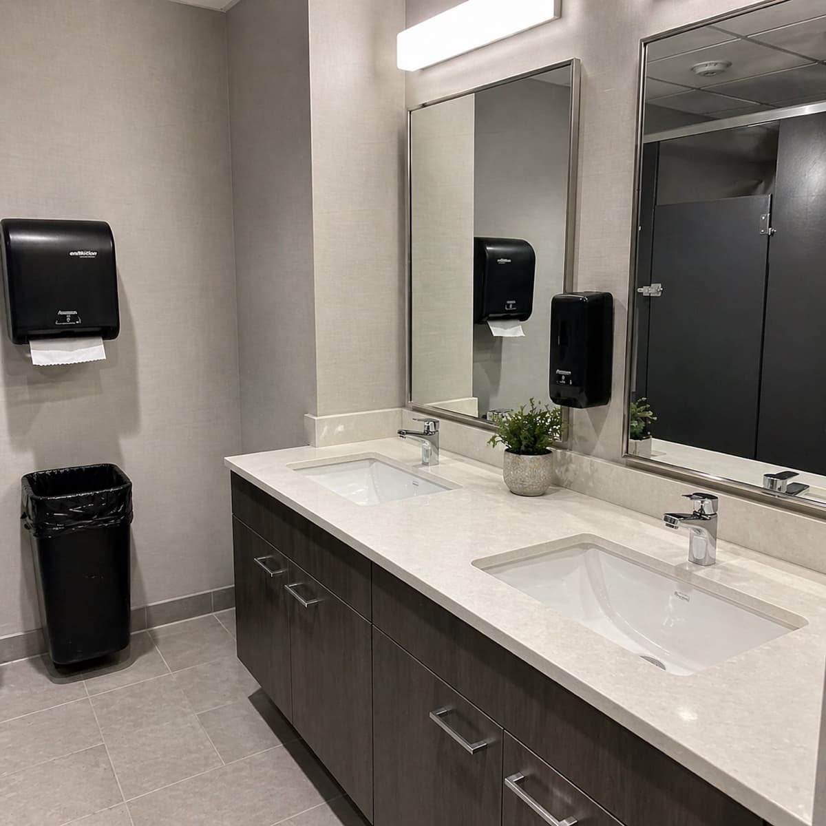 Clean commercial washroom with restocked paper and soap dispensers
